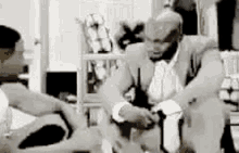 a man in a suit is sitting on a couch in a room .