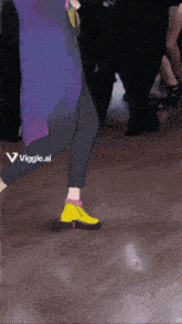 a person wearing a pair of yellow shoes with a viggle.ai sticker on the bottom
