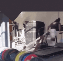a blurred image of a gym with a treadmill and dumbbells including one that says ' gs '