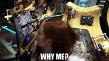 a woman is standing in front of a machine with the words why me written on it