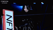 a woman in a black outfit is standing in front of a sign that says nfc