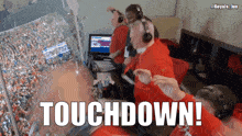 a group of people are watching a football game and the words touchdown are on the screen