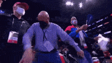 a group of men wearing face masks are standing in a stadium .