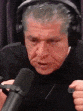 a man wearing headphones and a microphone is making a funny face .