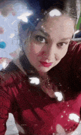 a woman in a red shirt is taking a selfie with butterflies on her face