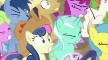 a group of ponies are standing next to each other and one of them is looking at the camera