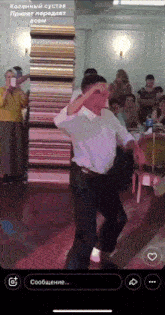 a man in a white shirt is dancing in front of a stack of books in a foreign language