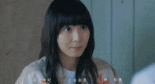 a close up of a woman 's face with chinese writing behind her