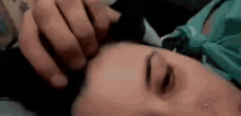 a close up of a person laying on a bed with a cat on their head .
