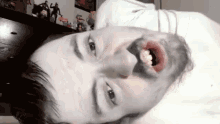 a man with a beard is laying down with his mouth open