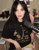 a woman wearing a black shirt that says francisco is sitting in front of a pink chair