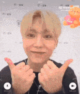 a man with blonde hair is giving a thumbs up