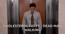 a man is walking down an elevator with the words `` cholesterol fatty ... dead man walking '' .