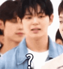 a group of young men are standing next to each other with a question mark on their faces .