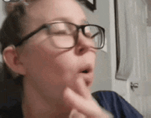 a woman wearing glasses is making a funny face with her mouth open .