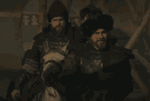 a man with a beard is standing next to another man with a beard