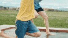 a man in a yellow shirt is kneeling down next to a woman