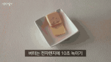 a person pouring sauce into a white bowl with korean writing