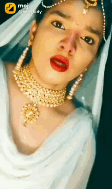 a woman is wearing a white dress and gold jewelry and a killerlady logo
