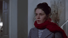 a woman with a scarf around her neck is standing in front of a sign that says what the fluff