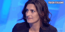 a woman with a microphone in her ear is on a tv show and the words trash italiano are above her