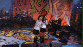 two girls singing on a stage with a nbc logo in the background