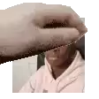 a person is covering their face with a piece of paper .