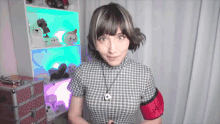 a woman wearing a plaid shirt and a red armband that says ' a.m. ' on it