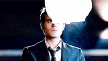 a man in a suit and tie is standing in front of a speech bubble .