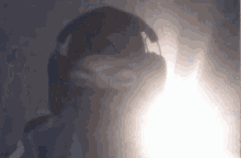 a shadow of a person wearing headphones against a dark background
