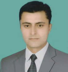 a man in a suit and tie poses for a photo