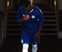 a man wearing a blue shirt with the word chelsea on the front