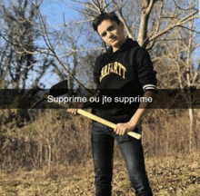 a man wearing a carhartt hoodie holds an axe