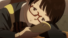 a girl wearing glasses looks at her phone