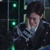 a man in a suit is crying with a ring on his finger in front of a green background