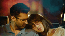 a man and woman wearing glasses are sitting next to each other with their eyes closed
