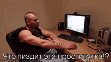 a man is sitting in front of a computer with russian writing on the bottom of the screen