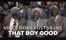 a group of older men are sitting in a crowd and laughing .