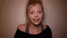 a young woman is making a funny face and smiling .