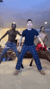 a group of men are dancing together in a living room in pajamas .