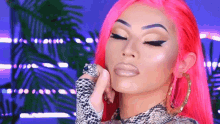 a woman with bright pink hair and a ring on her finger