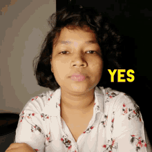 a woman in a floral shirt says yes in yellow