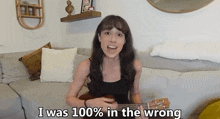 a woman singing while holding a guitar with the words i was 100 % in the wrong below her