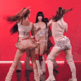 a group of girls are dancing in front of a red backdrop