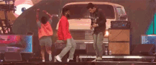a man playing a guitar and a man dancing on stage