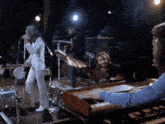a man playing a keyboard in front of a group of musicians
