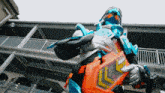 a person in a robot costume is holding a sword in front of a building