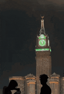 a clock tower with arabic letters on it