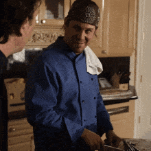 a man wearing a bandana with the letter e on it is smiling