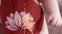 a red apron with a lotus flower embroidered on it